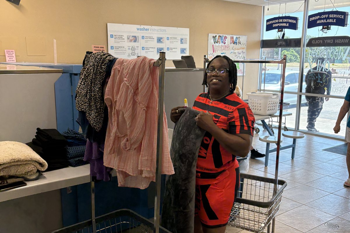 Customer folding laundry at WaveMAX Laundry on S 31st St, Temple, TX